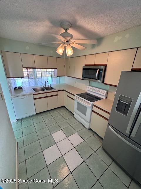 kitchen featuring light tile patterned floors, stainless steel appliances, sink, and white cabinets