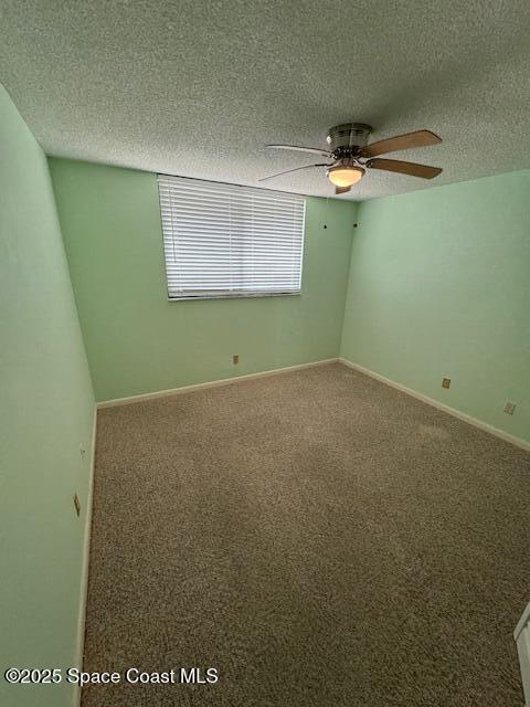 spare room with ceiling fan, carpet flooring, and a textured ceiling