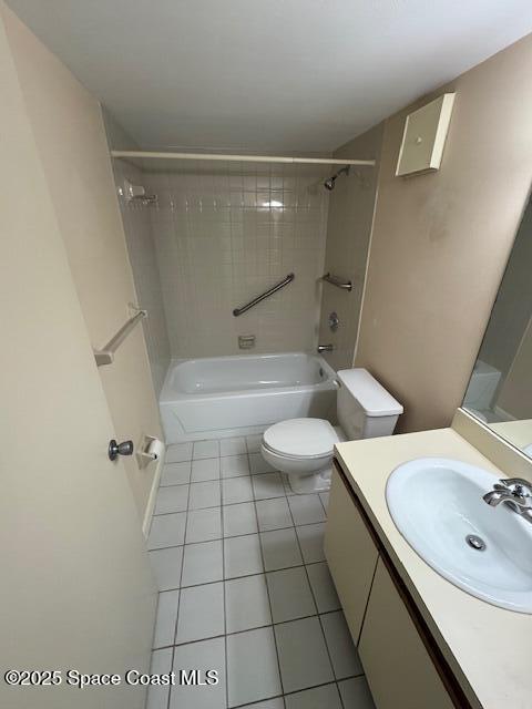 full bathroom featuring tiled shower / bath, vanity, tile patterned floors, and toilet