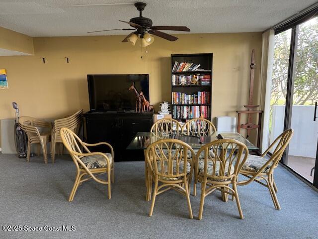 living area featuring floor to ceiling windows, carpet, ceiling fan, and a textured ceiling