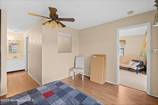 bedroom featuring ceiling fan, wood-type flooring, sink, and ensuite bathroom