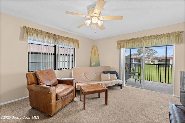 carpeted living room with ceiling fan and a textured ceiling