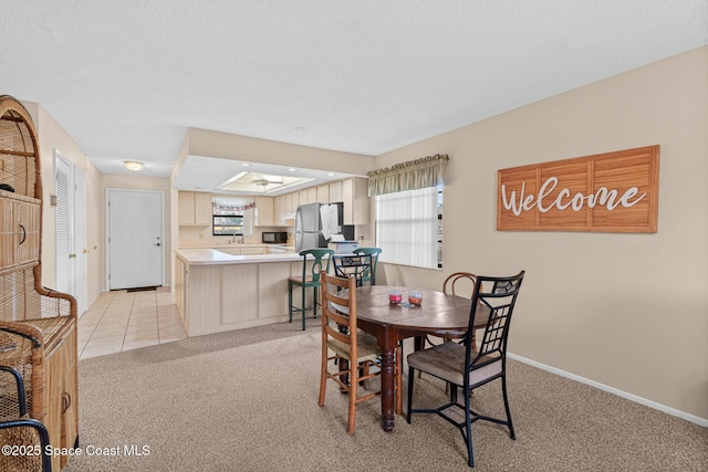 carpeted dining area with sink