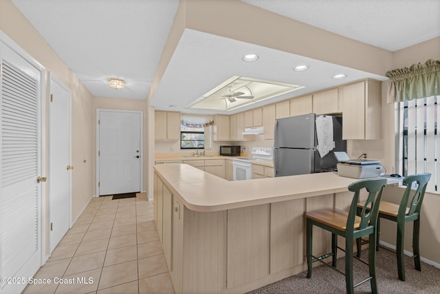 kitchen featuring kitchen peninsula, stainless steel fridge, ceiling fan, white range with electric cooktop, and sink