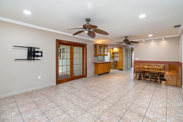 unfurnished living room with ceiling fan, rail lighting, a textured ceiling, and crown molding