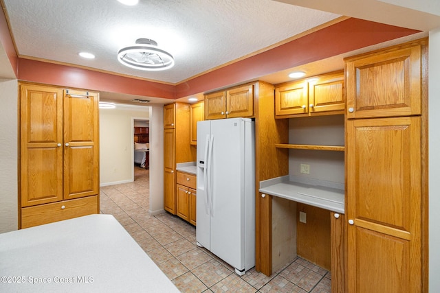 kitchen with light tile patterned floors, white refrigerator with ice dispenser, and a textured ceiling