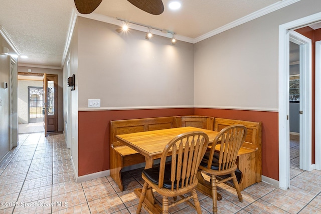 dining area featuring ceiling fan, a textured ceiling, ornamental molding, and track lighting