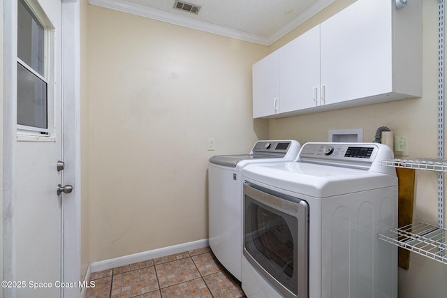 laundry room with cabinets, crown molding, and washing machine and clothes dryer