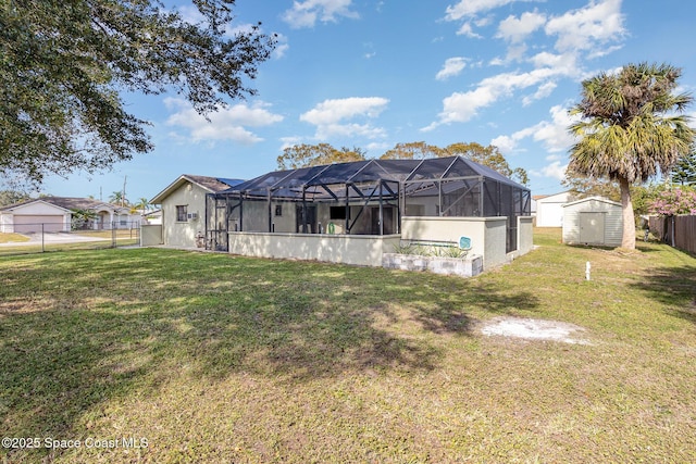 back of house featuring a yard, glass enclosure, and a storage shed