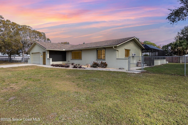 single story home with a garage and a lawn