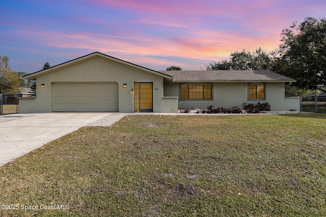 ranch-style house with a garage and a lawn