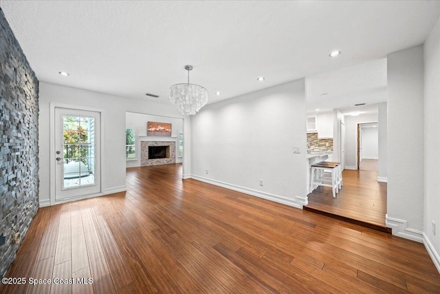 unfurnished living room featuring hardwood / wood-style floors and an inviting chandelier