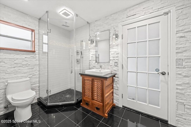 bathroom featuring tile patterned flooring, vanity, an enclosed shower, and toilet