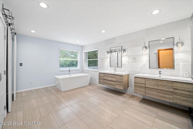 bathroom with tile patterned floors, vanity, and a tub