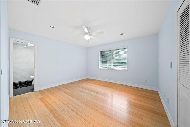 unfurnished bedroom featuring hardwood / wood-style floors, ensuite bathroom, and ceiling fan