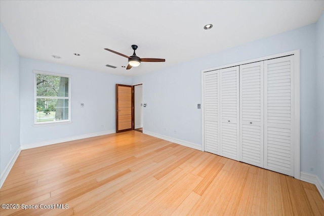 unfurnished bedroom featuring a closet, light hardwood / wood-style floors, and ceiling fan