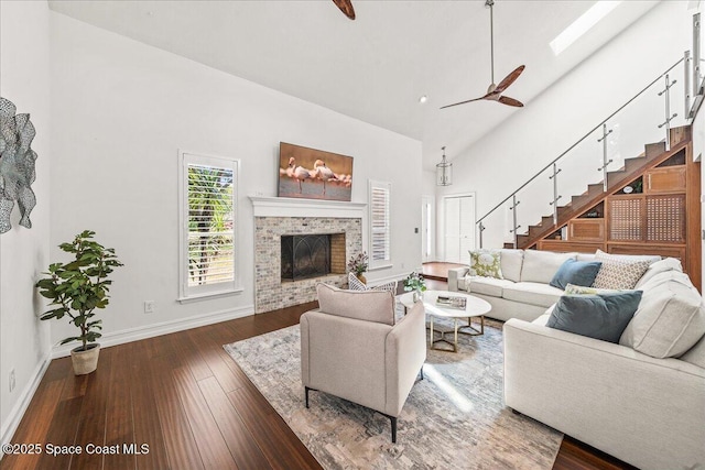 145 Crispin St, Merritt Island, FL 32952 - living area with baseboards, stairway, wood-type flooring, a brick fireplace, and high vaulted ceiling