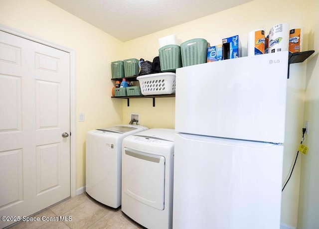 laundry room with light tile patterned flooring and washing machine and clothes dryer