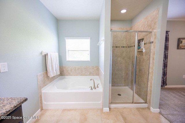 bathroom with tile patterned floors, vanity, and shower with separate bathtub