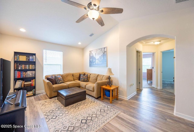 living room featuring ceiling fan, vaulted ceiling, and light hardwood / wood-style flooring