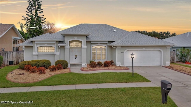 view of front of property featuring a garage and a yard