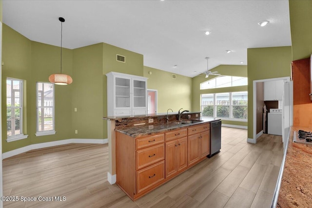 kitchen featuring washer / dryer, ceiling fan, dishwasher, pendant lighting, and sink