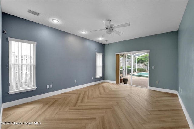 empty room with ceiling fan and light parquet flooring