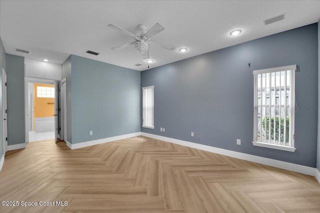 unfurnished room featuring ceiling fan and light parquet floors