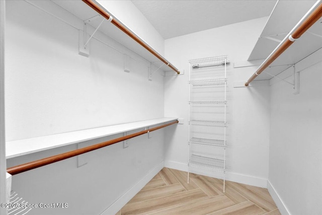 spacious closet with light parquet flooring