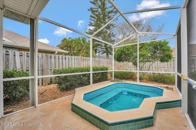 view of pool featuring glass enclosure, a patio area, and a hot tub