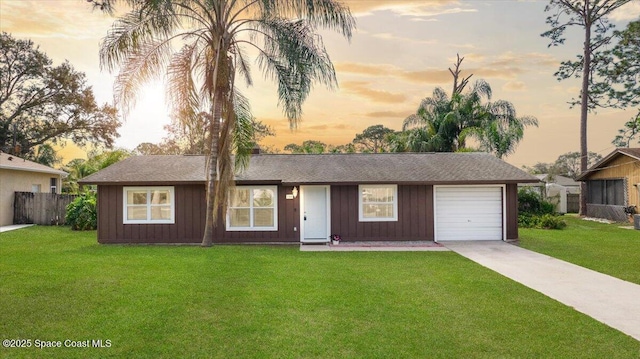 ranch-style home with a garage and a lawn