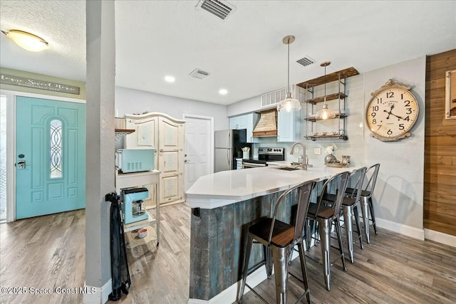 kitchen featuring appliances with stainless steel finishes, sink, a kitchen breakfast bar, and kitchen peninsula