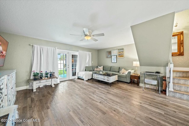 living room featuring french doors, wood-type flooring, ceiling fan, and a textured ceiling