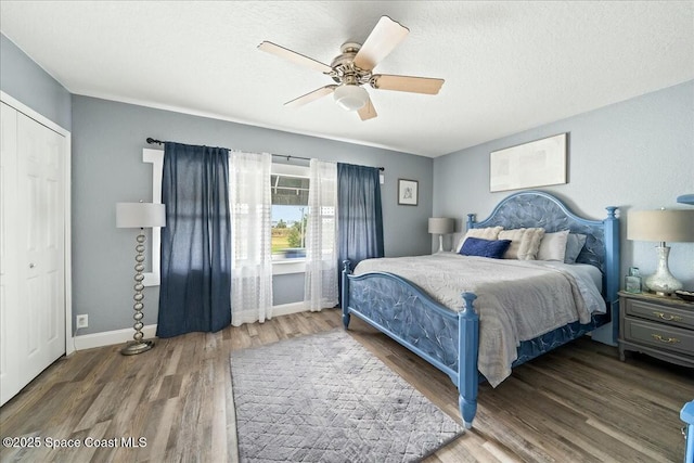 bedroom featuring ceiling fan, a closet, a textured ceiling, and wood-type flooring