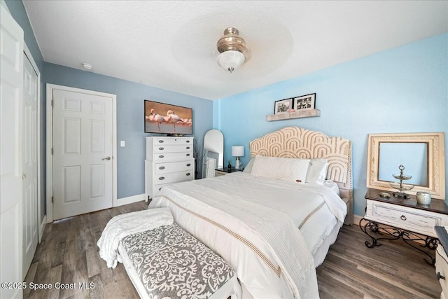 bedroom with a closet, ceiling fan, and dark wood-type flooring