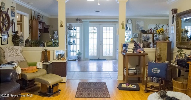 interior space featuring french doors, light tile patterned floors, ornate columns, and crown molding