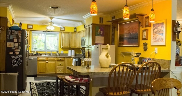 kitchen featuring a breakfast bar, ceiling fan, a textured ceiling, appliances with stainless steel finishes, and kitchen peninsula