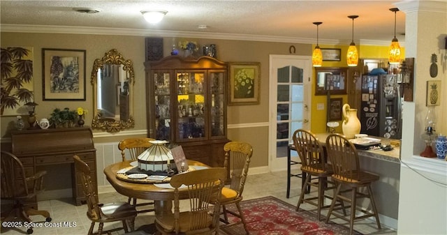 dining room featuring ornamental molding and a textured ceiling