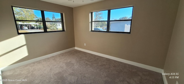 unfurnished room with ceiling fan and carpet