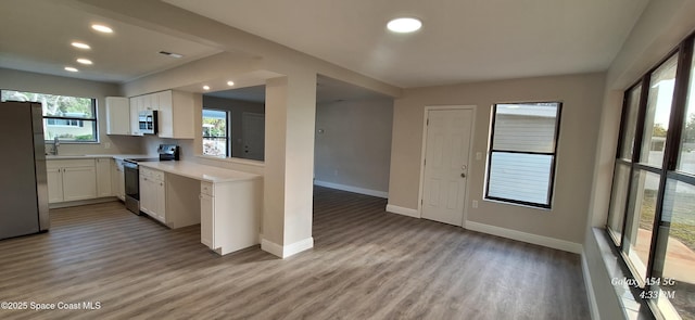 kitchen featuring sink, white cabinetry, light hardwood / wood-style flooring, and stainless steel appliances