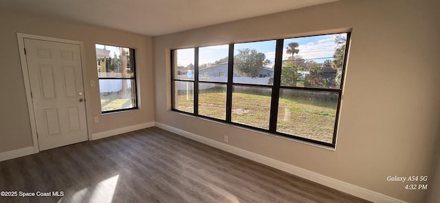 unfurnished room with dark hardwood / wood-style flooring