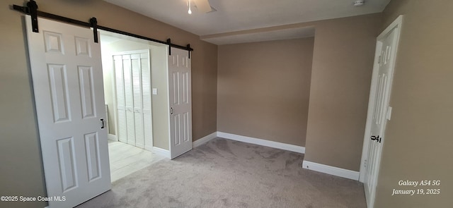 carpeted empty room featuring a barn door