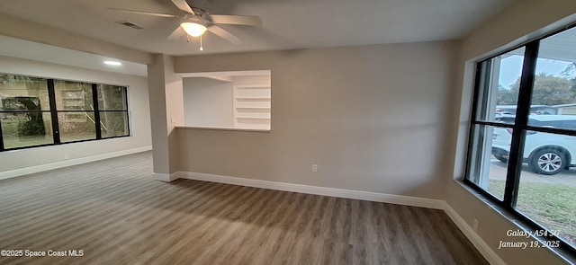 spare room with wood-type flooring, a wealth of natural light, and ceiling fan