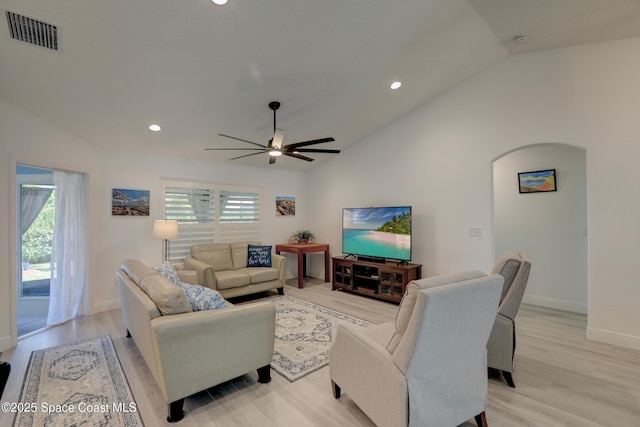 living room featuring ceiling fan, light hardwood / wood-style floors, and vaulted ceiling