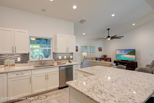 kitchen featuring white cabinetry, dishwasher, sink, and light stone countertops