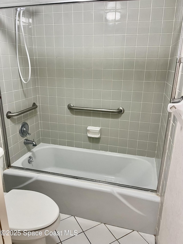 bathroom featuring tile patterned floors, toilet, and tiled shower / bath
