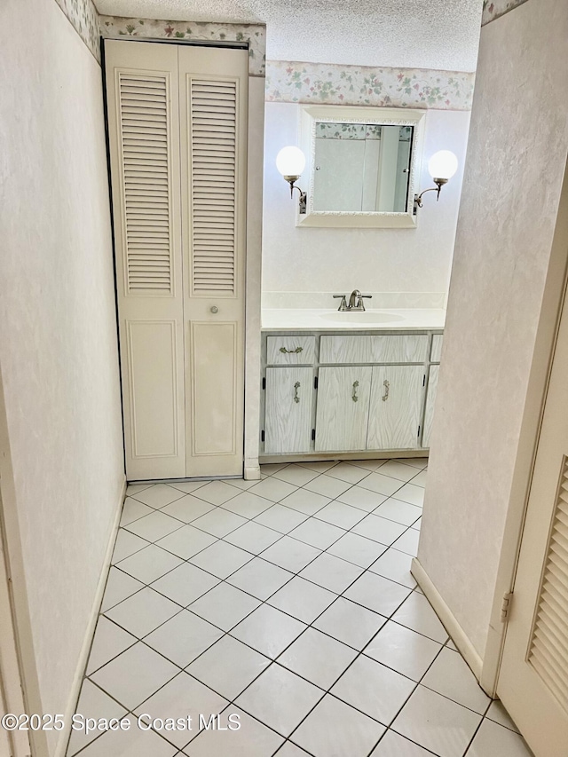 bathroom with a textured ceiling, tile patterned floors, and vanity