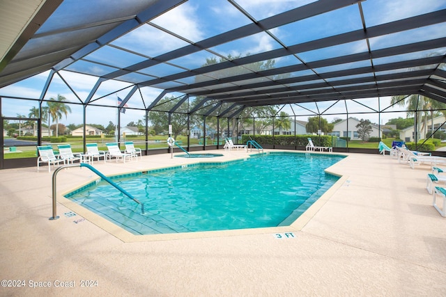 view of swimming pool featuring a lanai, an in ground hot tub, and a patio