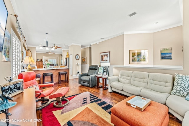 living room with ceiling fan, wood-type flooring, and ornamental molding