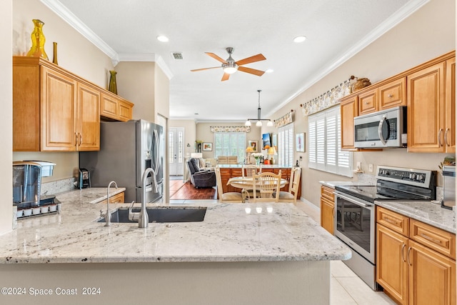 kitchen with sink, hanging light fixtures, ornamental molding, light stone counters, and stainless steel appliances